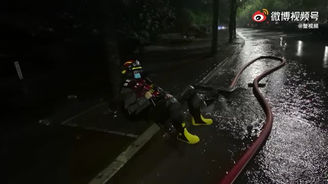 心疼！消防员排涝10多小时雨中坐路边睡着